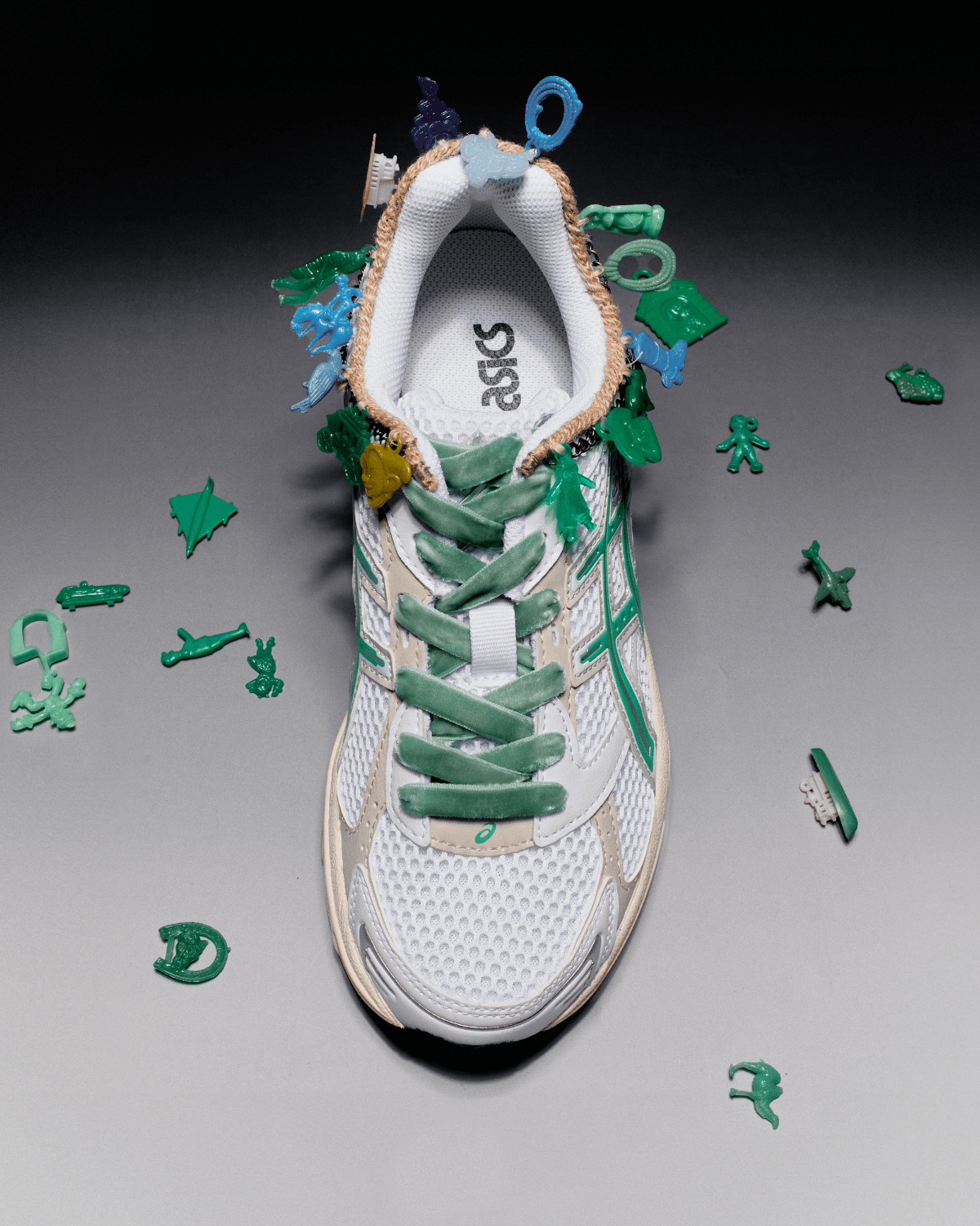 ヴィンテージチャームが縫い付けられた〈アシックス〉スニーカー