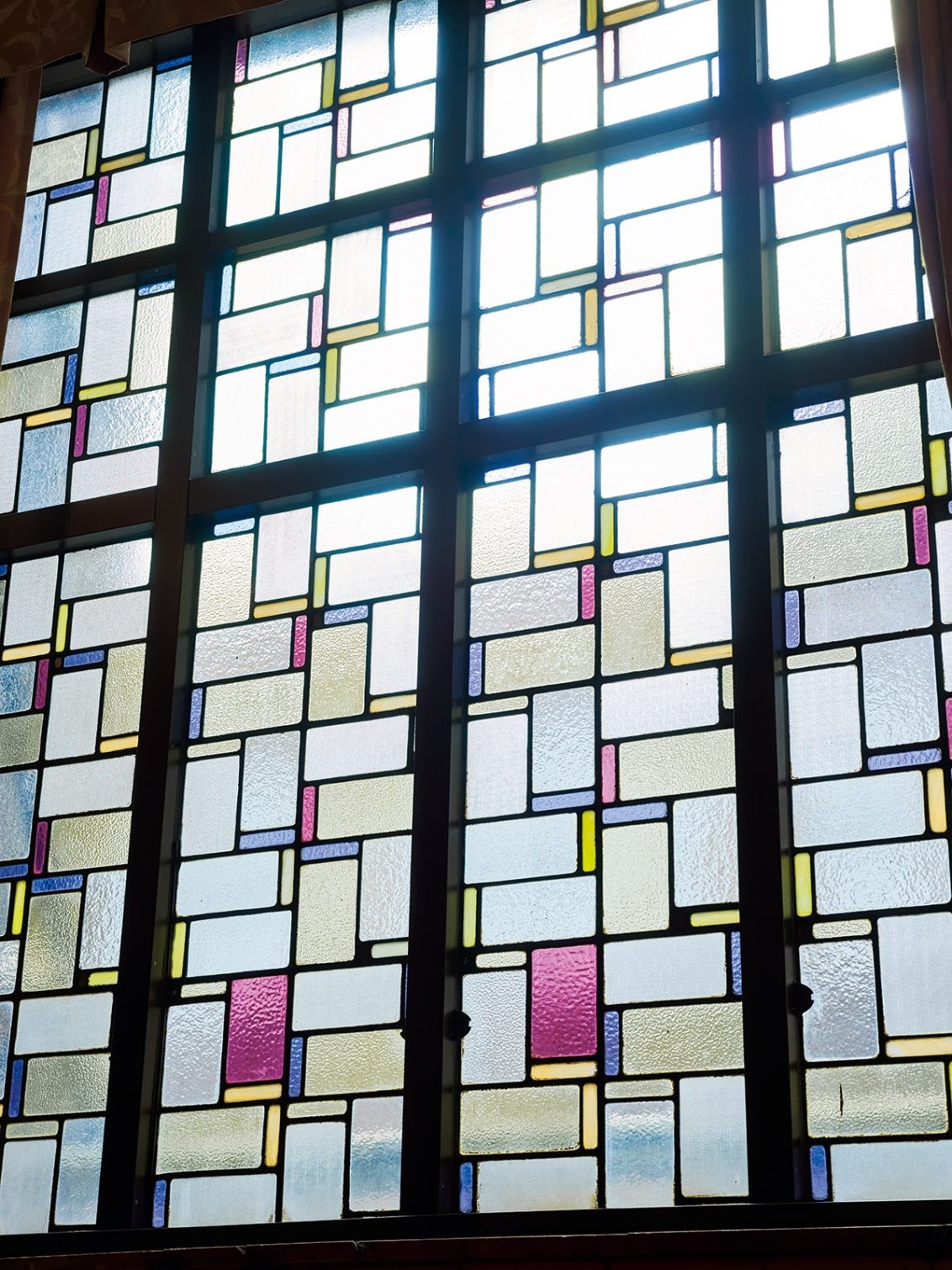 階段踊り場のステンドグラス。100年前のモダンな意匠に見惚れる。