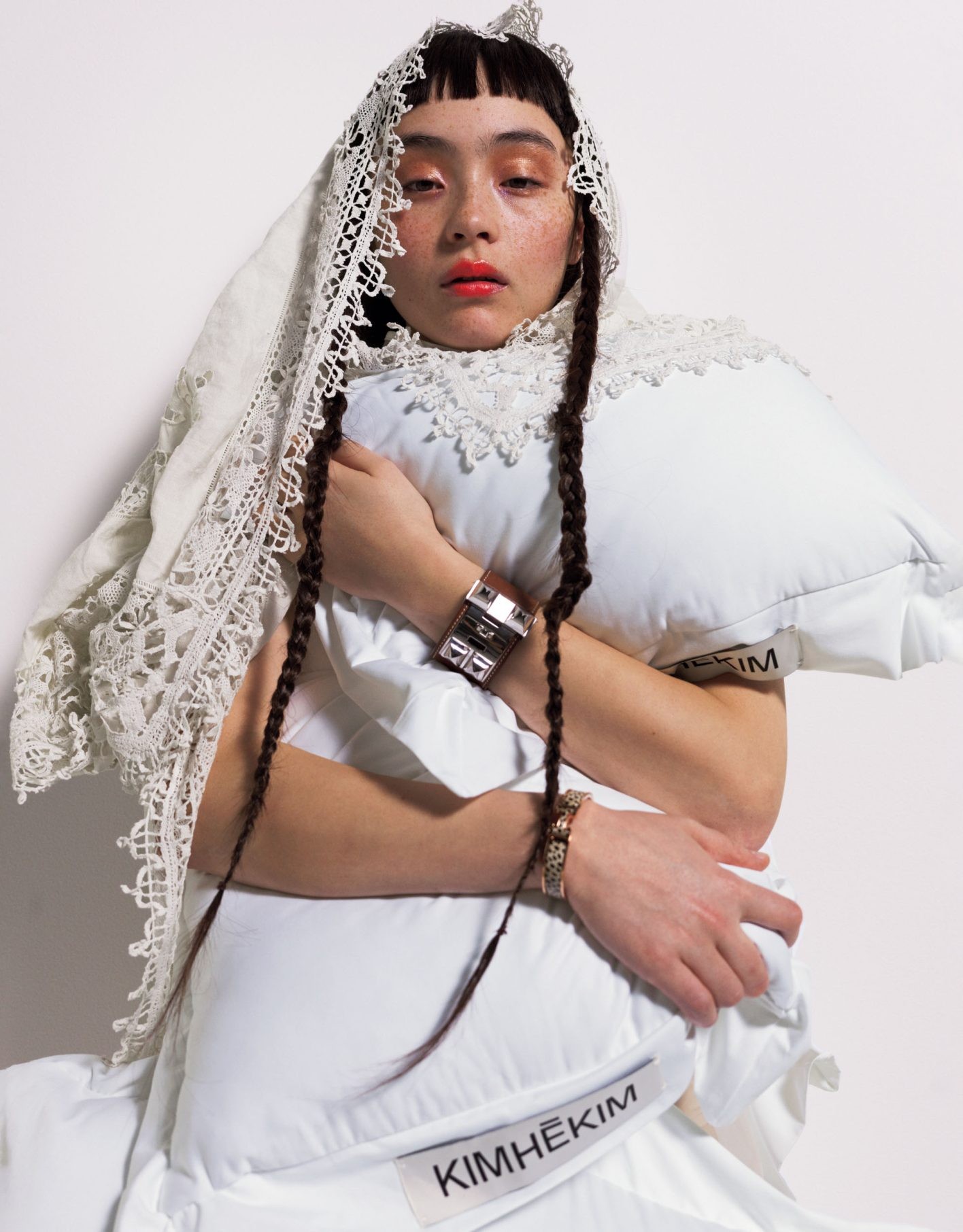 アンティーク・ホワイトのファンタジックな魅力を生かしたスタイリング。頭にかけたのは縁のレース飾りが美しいアンティーククロス。正方形の大判を選んでストール使いした。ドレス ¥385,700（キムへキム | カーブストア）／クロス ¥23,100（ジャンヌ バレ）／レザーブレスレット 左手 ¥250,800、エナメルブレスレット 右手 ¥136,400（共にエルメス | エルメスジャポン）
