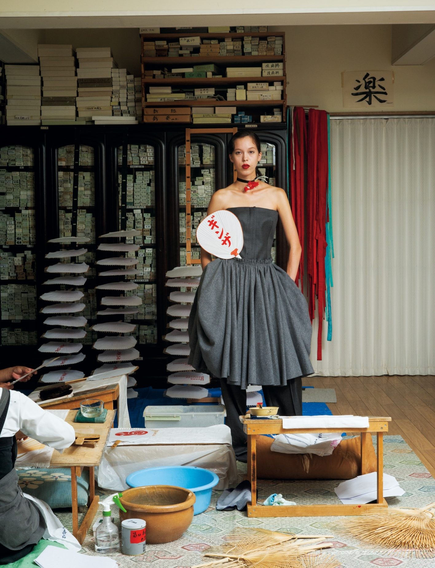 ジャンプスーツ ¥924,000（ジバンシィ by サラ・バートン | ジバンシィ ジャパン）／スカート ¥223,300（アミ パリス | アミ パリス ジャパン　オンライン カスタマーサービス）／首元のコサージュ ¥22,000（フォルテ フォルテ | コロネット）／首に巻いたリボン＊スタイリスト私物／オリジナル京丸うちわ ¥4,950（小丸屋住井）