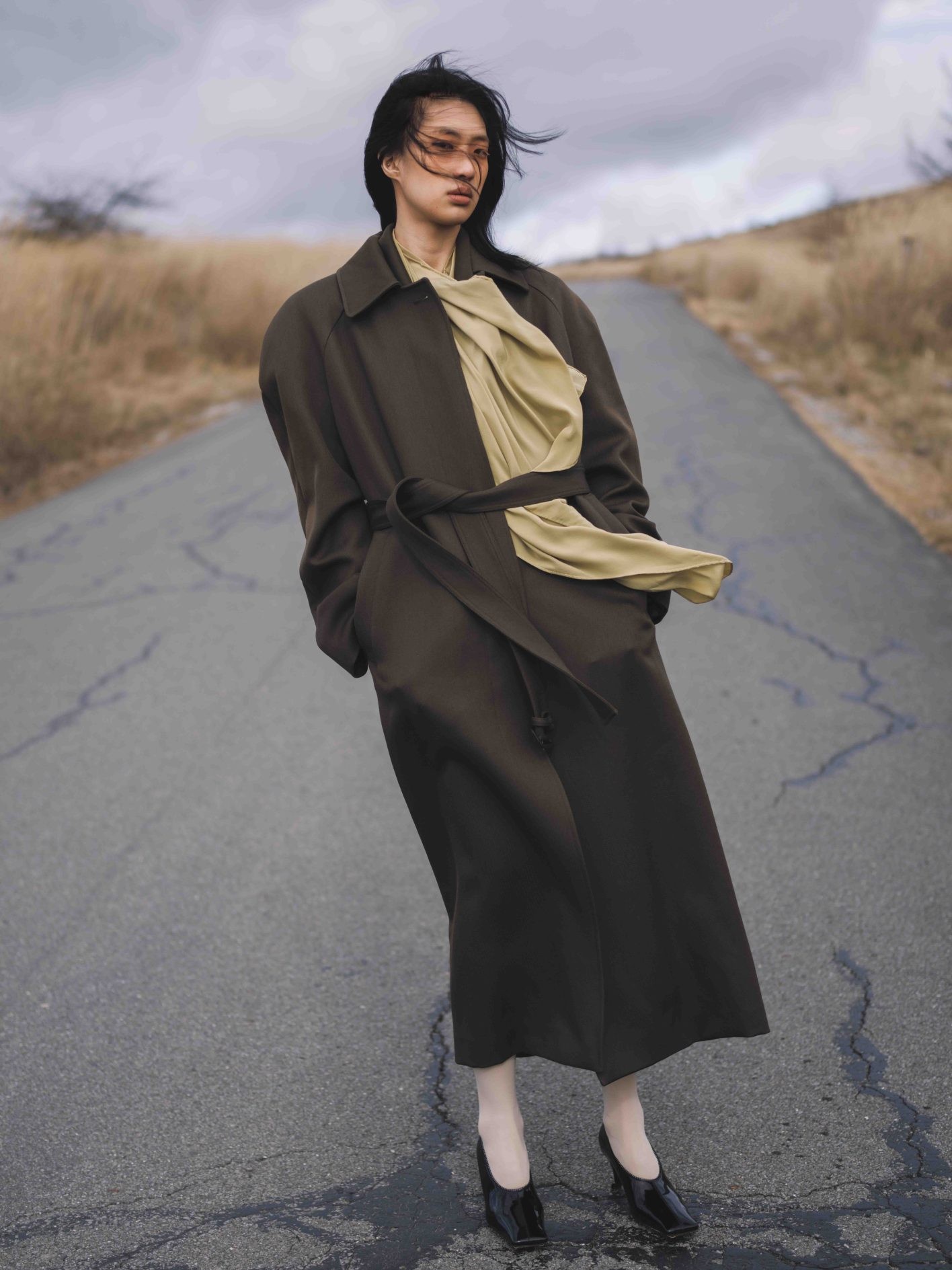 「ヘアメイクの裏テーマは、“余裕のある女性”。かっこ良くて粋なこの佇まいに、それが集約されている気がします」（UDAさん）。ミニマムなデザインのステンカラーコート。働く女性のあらゆる人生のステージに寄り添うワードローブを提案した、〈ステラ マッカートニー〉から。コート ¥469,700、シューズ ヒール6.5cm ¥124,300（共にステラ マッカートニー | ステラ マッカートニー ジャパン）／スカーフ、タイツ＊スタイリスト私物