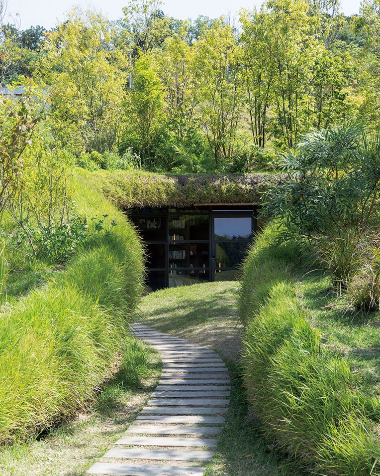 緑の山に埋もれ、岩壁に潜む。昨今の名建築のキーワードとは