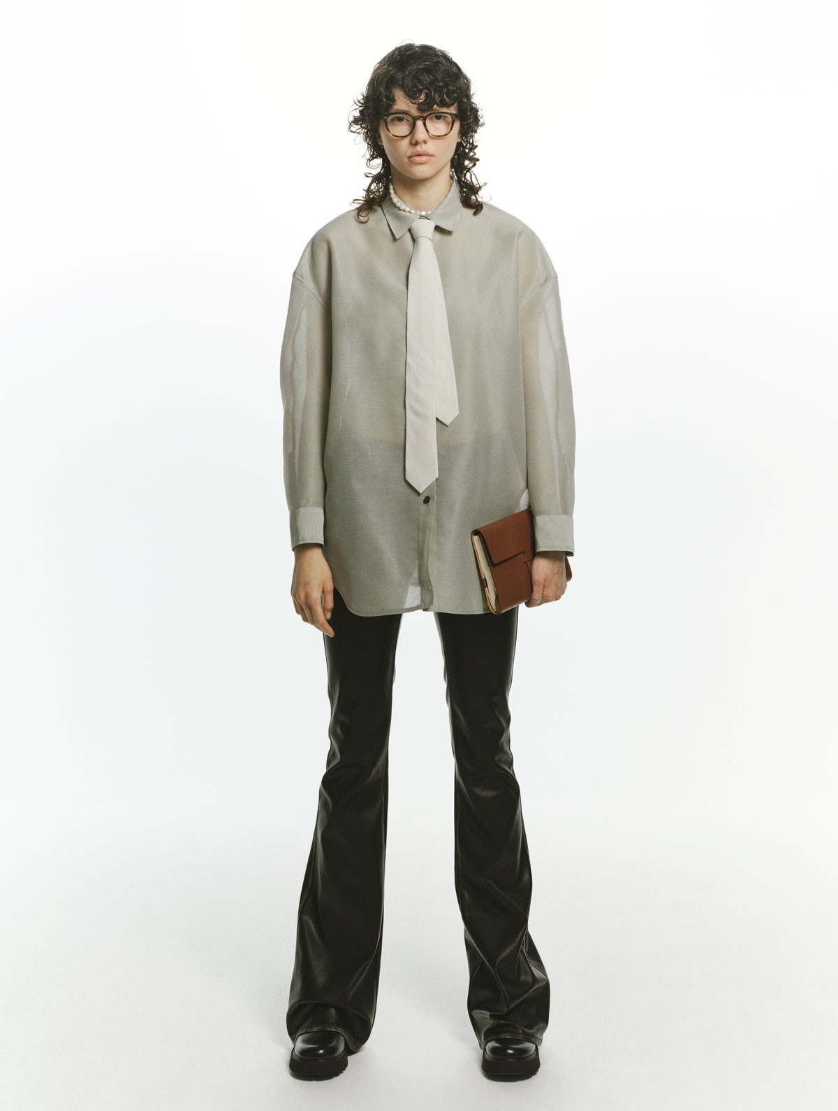 パンツ ¥61,600(ディーゼル | ディーゼル ジャパン)/シャツ ¥36,300(イロット | ザ・ウォール ショールーム)/メガネ ¥62,810(オリバーピープルズ | ルックスオティカジャパン カスタマーサービス)/ネクタイ ¥14,300(グラフペーパー | グラフペーパー 東京)/ネックレス ¥50,600(ララガン | ララガンデザイン)/手に持った本のカバー ¥46,200(オーラリー)/シューズ ヒール6cm ¥29,700(カンペール | カンペールジャパン)