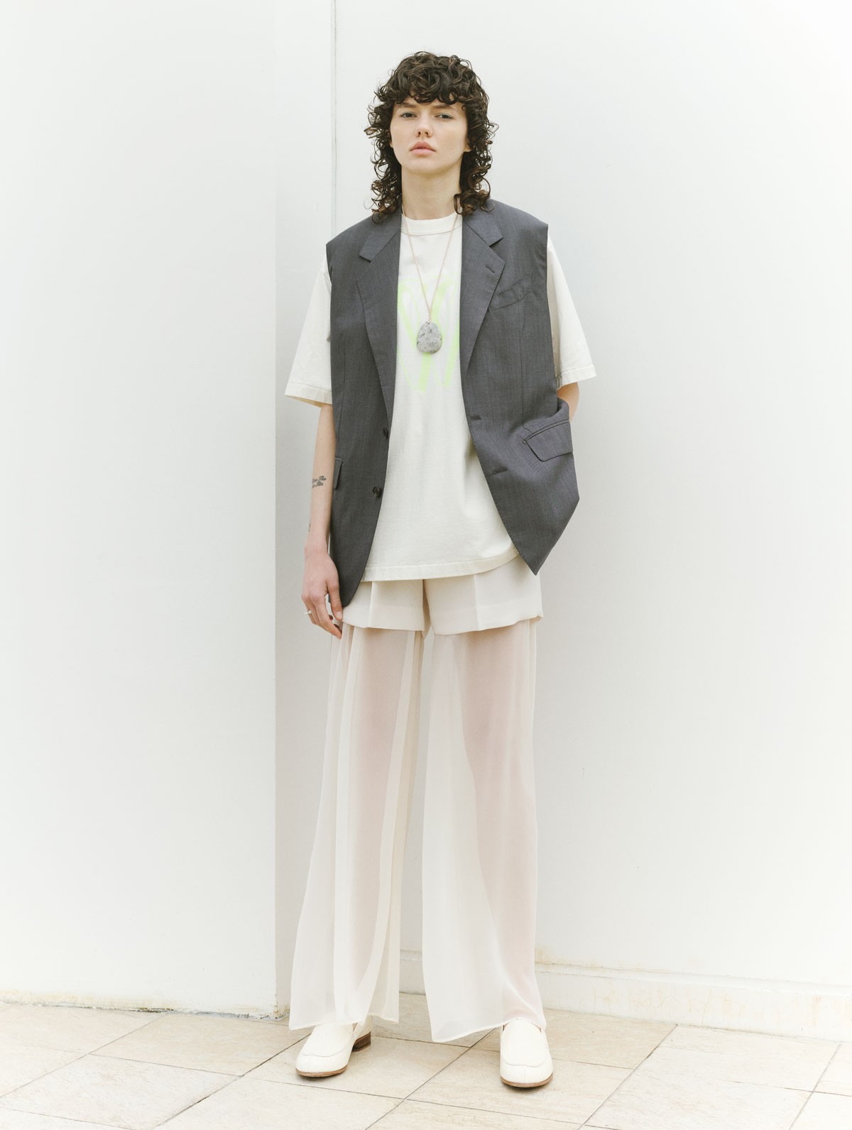 パンツ ¥41,800(ハイク | ボウルズ)/ベスト ¥110,000(バウト | ボウト)/Tシャツ ¥15,950(ブラームスルーツストック | ワンダリズム)/ネックレス ¥28,600(シャノンボンド | ギャルリー・ヴィー 丸の内店)/リング ¥9,900(マッソーズアンドマッソーズ)、シューズ ヒール2.5cm ¥117,700(ジアボルギーニ | 共にショールーム ロイト)