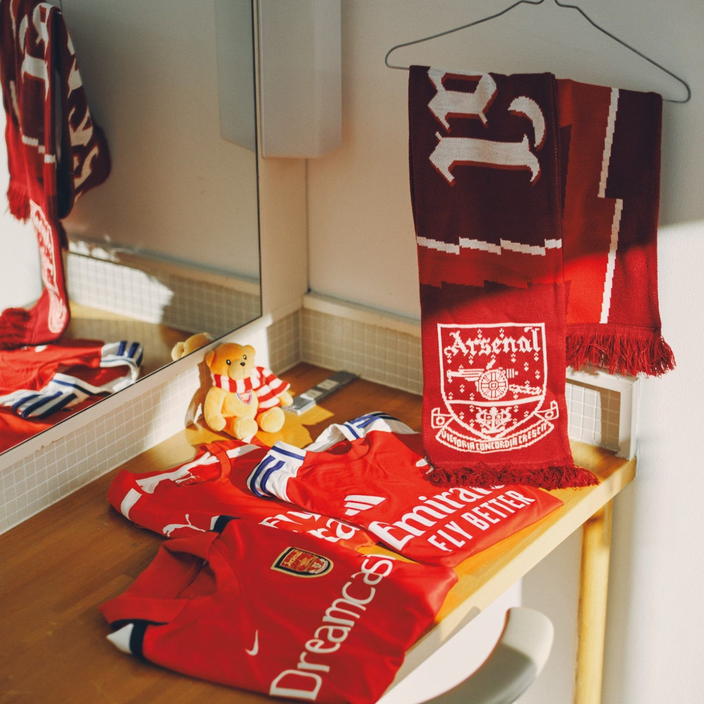 アーセナルFCのゲームシャツは鮮やかな赤。左 「『ドリームキャスト』がサポーターだった2001年(稲本潤一の加入年)のもの。知り合いが中学生の時に着ていたという貴重な一着をいただきました」 中 ロンドンで一時期ルームシェアをしていた同居人からのプレゼント。右 現監督ミケル・アルテタが選手だった時代のデザイン。マフラータオルはエミレーツ・スタジアムで購入。公式グッズのぬいぐるみは普段使いのリュックに。