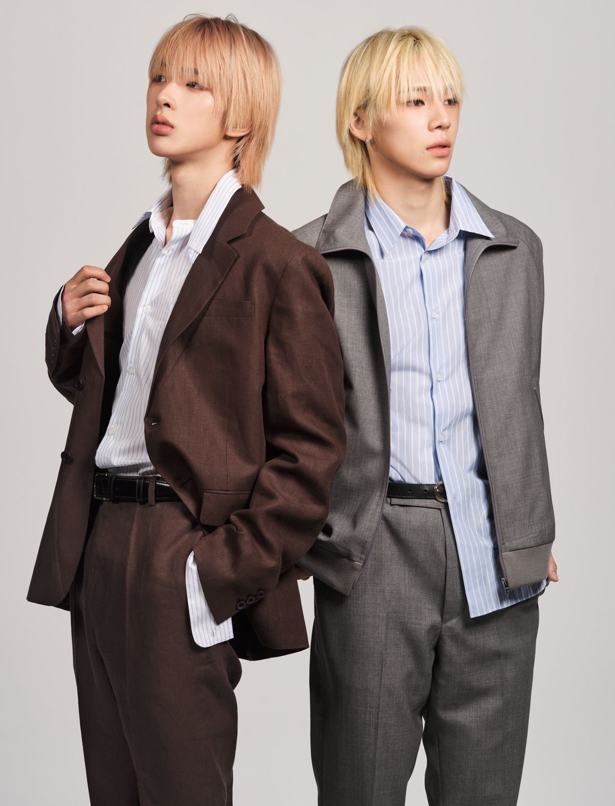 「ブルゾンの裾がスウェット生地になっていて、大人っぽい雰囲気にカジュアル感がプラスされますよね」(SO GEON)。「セットアップの着心地が軽くて、踊りたくなりました!襟とカフスが取り外しできるシャツの造りがユニーク」(TOMOYA)。右_ブルゾン ¥357,500、シャツ ¥170,500、パンツ ¥214,500*以上予定価格(以上プラダ | プラダ クライアントサービス)/ベルト*スタイリスト私物 左_ジャケット ¥671,000、シャツ ¥225,500、パンツ ¥357,500、ベルト ¥90,200*以上予定価格(以上プラダ | プラダ クライアントサービス)