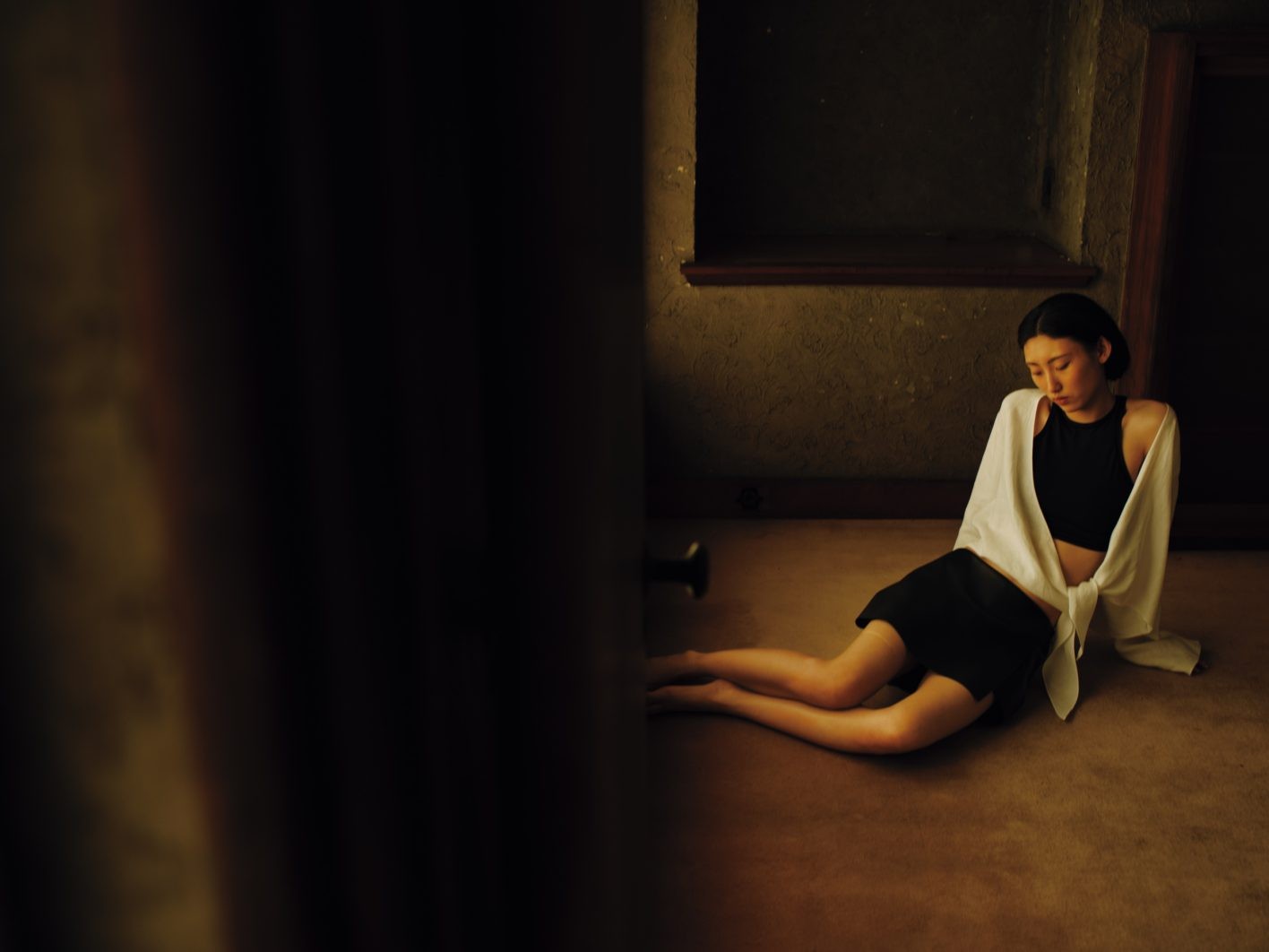 上品に露出するウエストと肩。「どんな風に肌を見せるのかを大切にしました」(井伊さん)。ショート丈トップとカーフレザーのミニスコート。ショールのように羽織ったヘンプのカシュクールジャケットが、装いに奥行きと、清々しい風の動きも感じさせる。ジャケット ¥85,800、スコート ¥132,000(共にコモリ | ワグ インク)/タンクトップ ¥31,900(ウォルフォード | リトルリーグ インク)