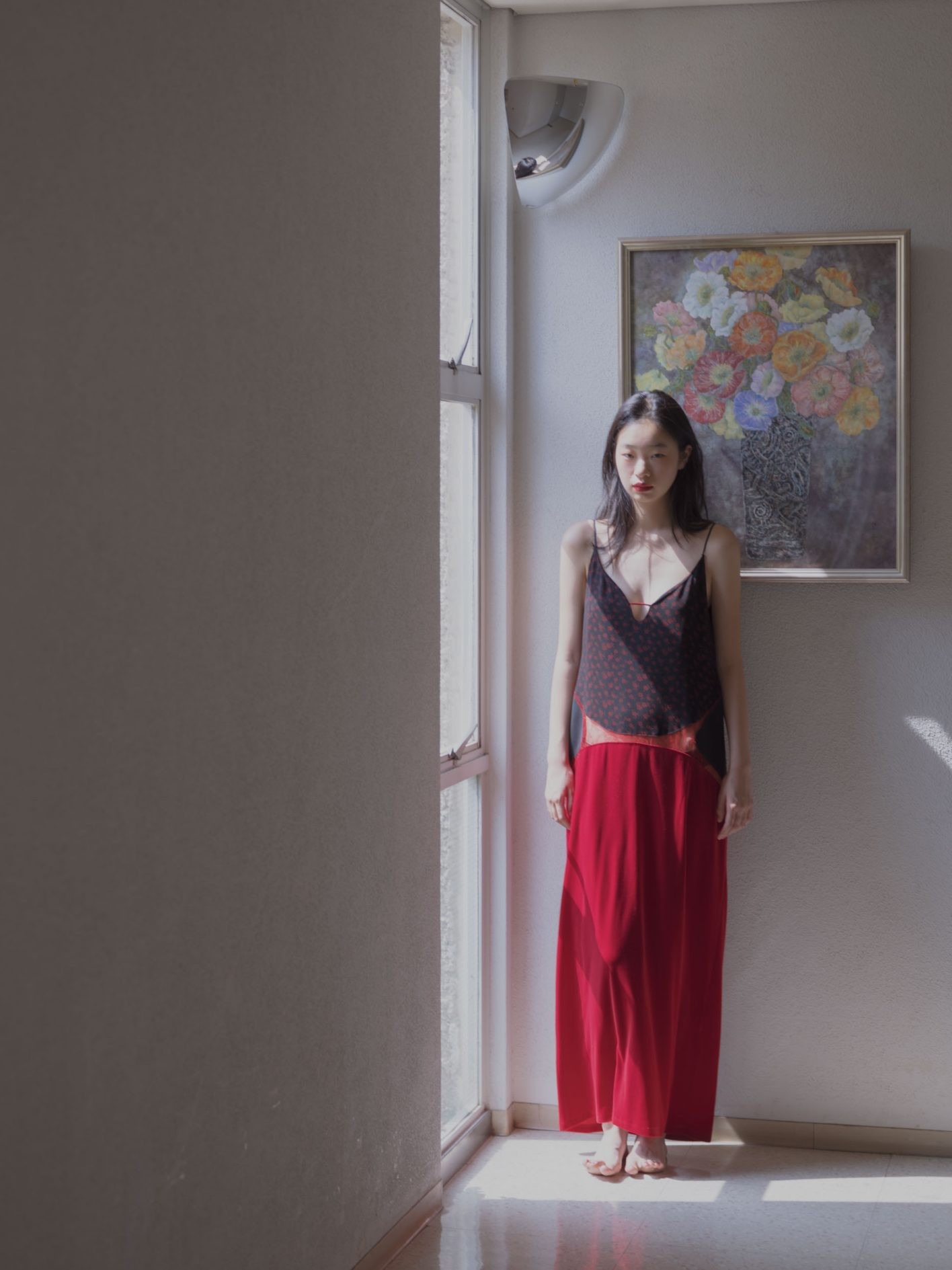 小花柄のジャカードと重厚なベロアを、レースの切り替えが大胆につなぐドレス。「スカートの質感とリンクする、こっくりヴィヴィッドな発色の赤を唇に。ジューシーで甘酸っぱい季節の気配を薫らせて」(UDAさん)。リップには〈M・A・C〉の〈ロックド キス インク リップカラー〉のルビー トゥルーを使用。キャミソールドレス ¥70,400(マメ クロゴウチ | マメ クロゴウチ オンラインストア)