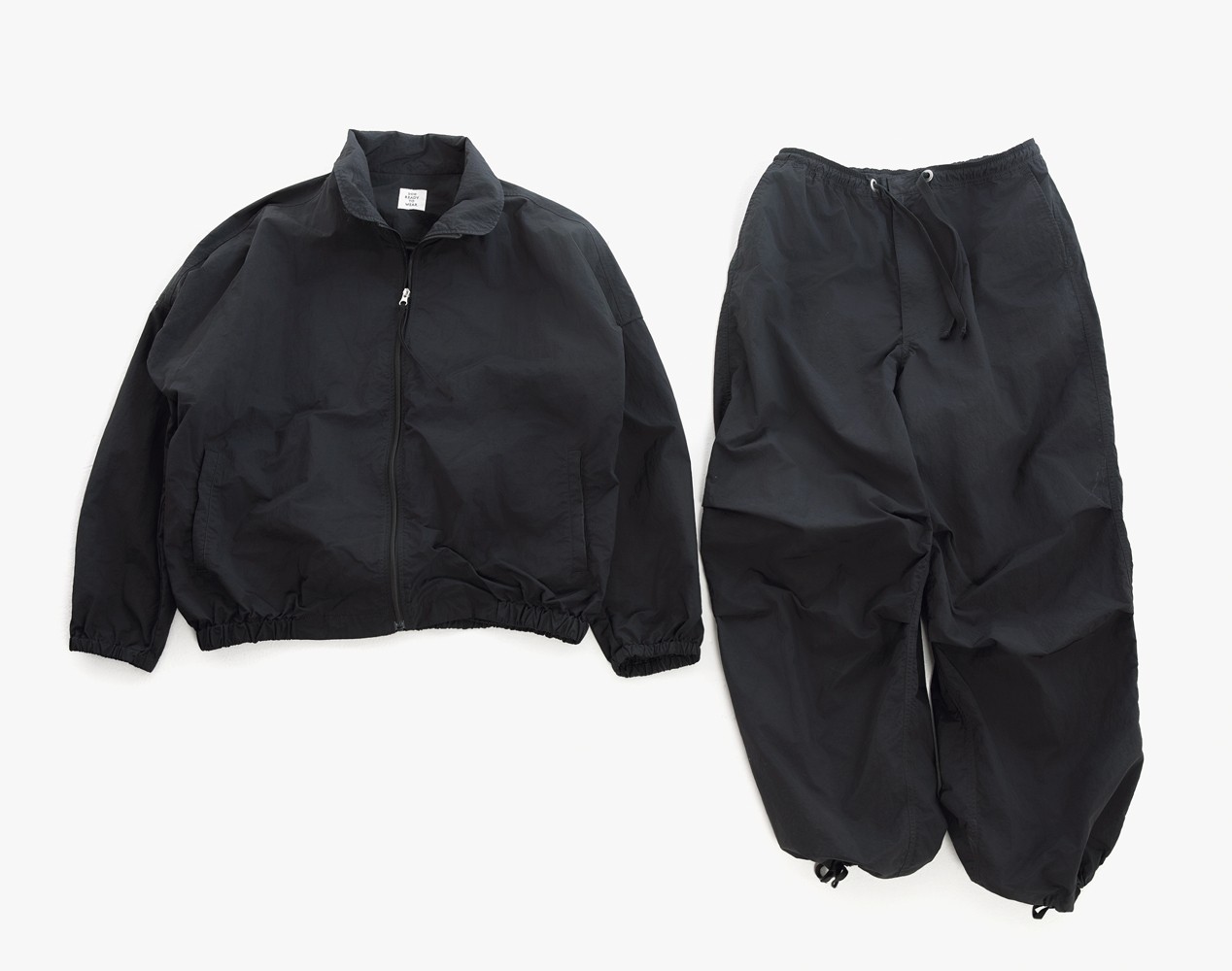 「2024-25AWの展示会で見かけてすぐ買いました。以来、真夏以外の時季は、ほとんどこのセットアップで過ごしてきました。僕が持っているのはブラックですが、グレーやネイビーがあっても可愛いですよね。ぜひ定番アイテムにしてほしい、と壮一郎さんにお願いしてるところです」と濱尾さん。上下共にアジャスターで裾の絞り具合を調整可能。軽く、機能性も◎