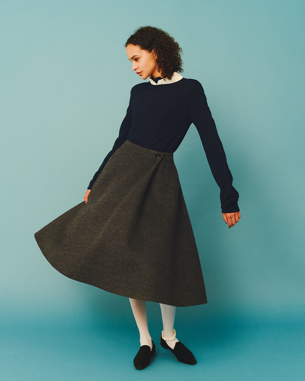 奇をてらわずレディに落とし込もう。フレアはやっぱりシルエットが命。美しい形のこちらは〈アディアム〉より。スカート ¥86,900、ニット*首に巻いたボウタイとセット ¥74,800、中に着たブラウス ¥68,200(以上アディアム | アディアム 東京ミッドタウン店)/ピアス ¥38,500(テッド・ミューリング | カ ジツ)/タイツ ¥1,650(セシリア デ ラファエル | ぽこ・あ・ぽこ)/アンクレット ¥53,900(サピア バハール | フィルグ ショールーム)/ローファー ¥36,300(シーセイ | ベイクルーズ カスタマーサポート)