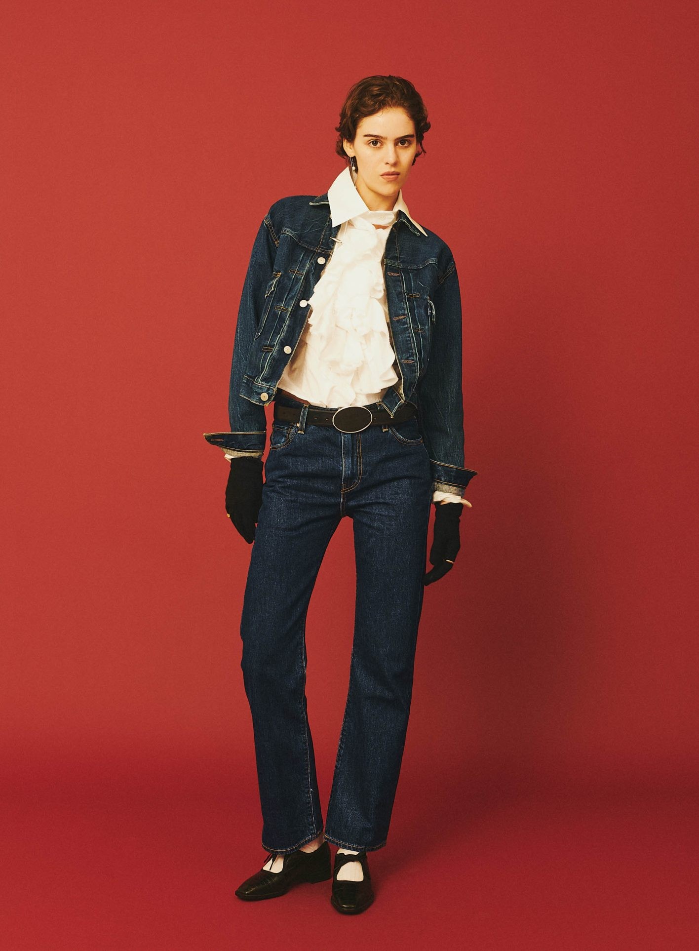 ドレッシーな手袋、ブラウスやベルトもデコラティブに。ここまで振り切っても過剰にならないのはデニムだからこそ成せる技。ジャケット ¥44,000、ジーンズ ¥26,400(共にリーバイス® ブルータブTM | リーバイ・ストラウス ジャパン)/ブラウス ¥137,500(ヴィヴィアン・ウエストウッド)/ピアス ¥148,500(シハラ)、リング 左手 ¥704,000(マイケル・アナスタシアデス + シハラ | 共にシハラ トウキョウ)/ジャケットに付けたヘアクリップ*2個セット ¥14,300(ジュスティーヌ クランケ | ザ・ウォール ショールーム)/リング 右手 ¥86,900(ソフィー ブハイ | エスケーパーズ アナザーワールド)/グローブ ¥14,300(アニエスベー)/ベルト ¥68,200(デアンシェ | エスアンドティ)/ソックス ¥2,640(ホイサム)/メリージェーン ¥64,900(カチム)