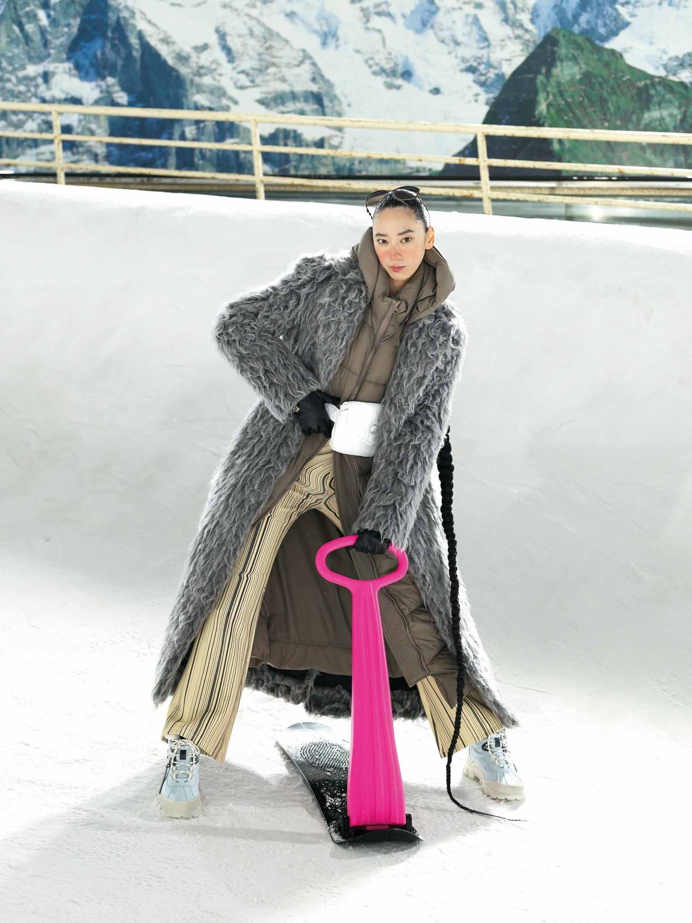 優雅に広がるシャギーコートと、フレアパンツが織りなす華麗なシルエット。リゾートスタイルに映えるロング丈のアウターは、ポーチでウエストマーク。凍った路面での歩行を想定したレザーブーツで、街中も雪山も快適に過ごせる。コート ¥201,300、アイウェア ¥38,940(共にディーゼル | ディーゼル ジャパン)/中に着たダウンコート ¥220,000、ウエストバッグ ¥31,000(共にカナダグース | カナダグースジャパン)/パンツ ¥15,900(デシグアル | デシグアルストア 銀座中央通り店)/グローブ ¥30,800(フミエタナカ | ドール)/スノーシューズ ¥57,200(アグ® | デッカーズ ジャパン)