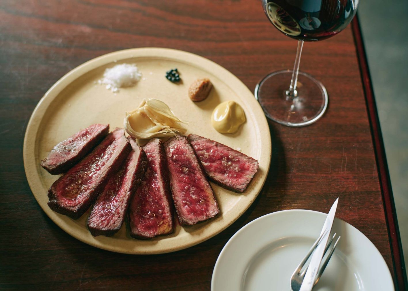 岩手産田村牧場の短角牛のウチモモステーキ(¥2,700/100g)。揚げ焼きにした絶妙な火入れで、外はカリッとしながら、内側はジューシーに。合わせるのは、フランスの作り手ジュリアン・クルトワの赤ワイン「アンセストラル」。ボトル¥8,000台〜。